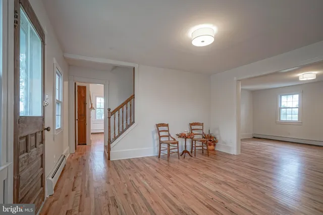 an empty room with wooden floor and a window
