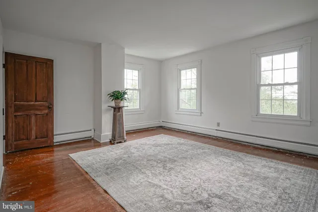 an empty room with windows and closet