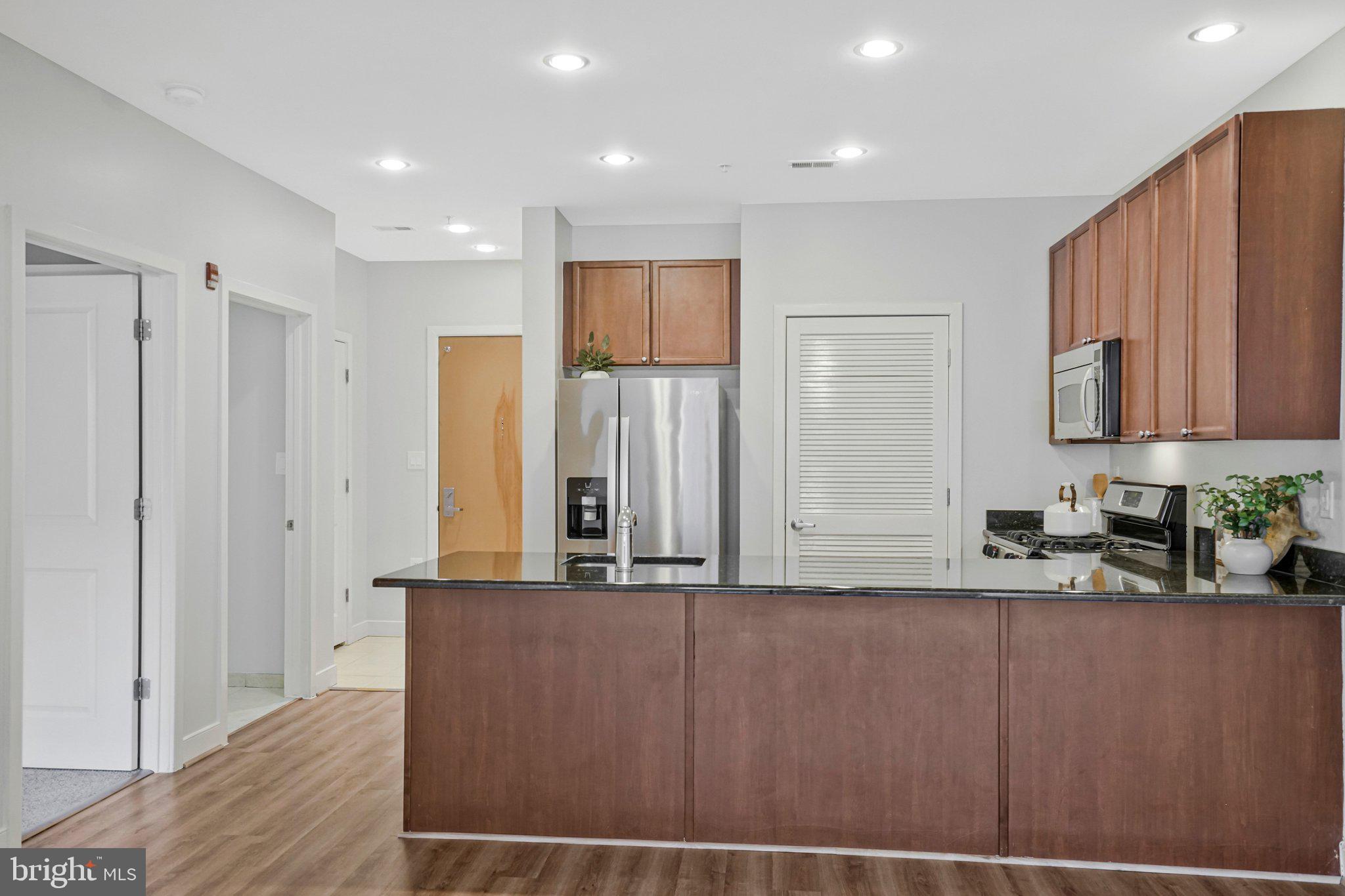 181 East Reed Avenue, Unit 206 Alexandria, VA 22305 - Photo 7 of 37 a kitchen with stainless steel appliances granite countertop a refrigerator and a sink