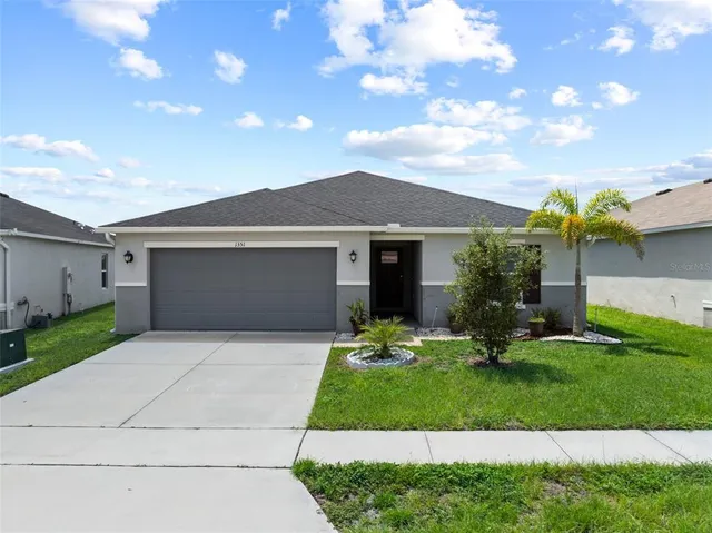 a front view of a house with a yard and garage