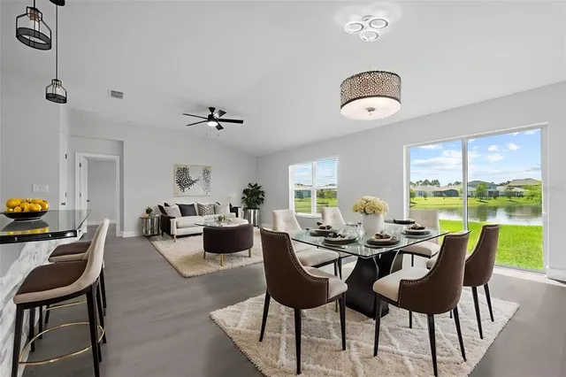a living room with furniture large window and wooden floor
