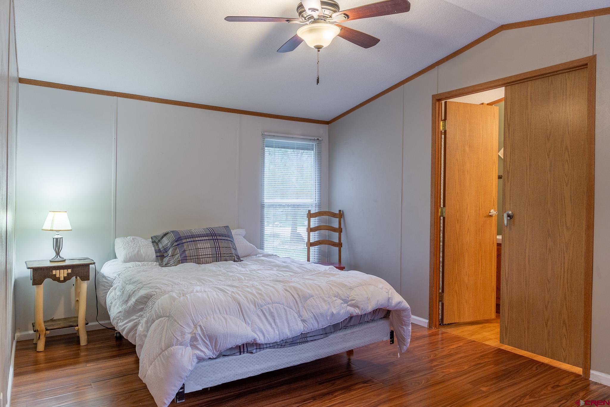 263 Mountain River Drive Bayfield, CO 81122 - Photo 8 of 21 a bedroom with a bed and a chandelier