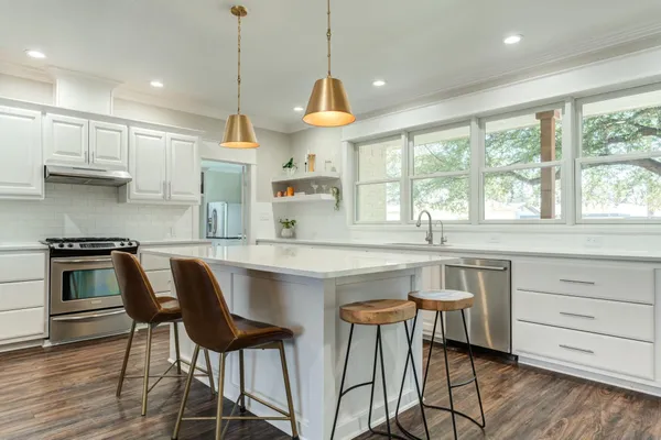 a kitchen with a table chairs stove and cabinets