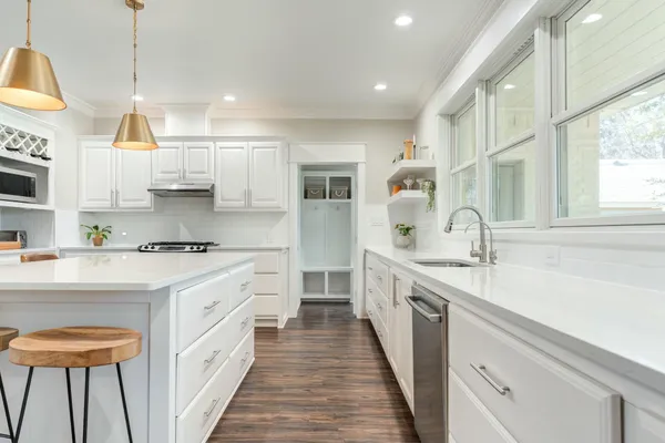 a kitchen with stainless steel appliances granite countertop a sink stove and refrigerator