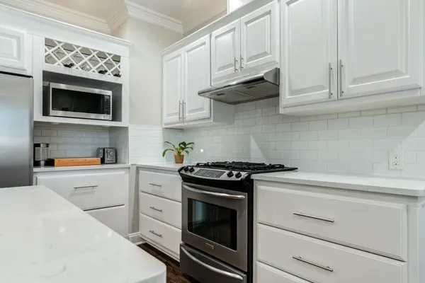 a kitchen with white cabinets and stainless steel appliances