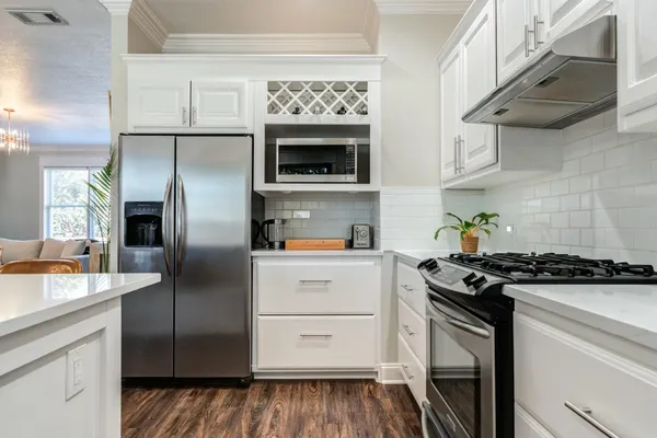 a kitchen with stainless steel appliances granite countertop a stove and a refrigerator