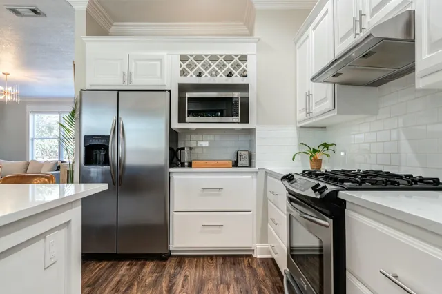 a kitchen with stainless steel appliances granite countertop a stove and a refrigerator
