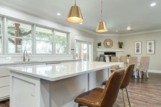 a kitchen with a stove a sink a dining table and chairs