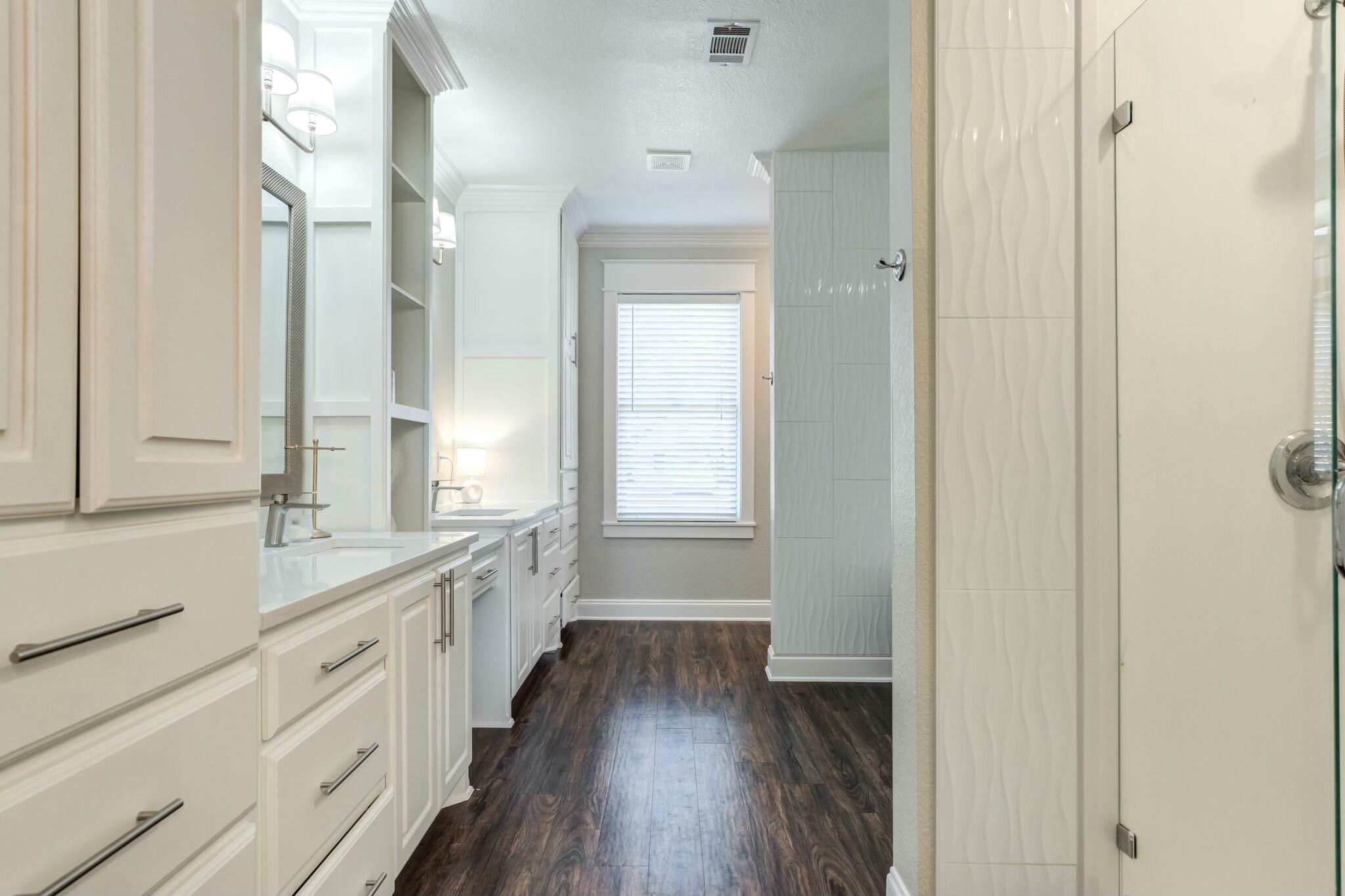 3219 22nd Street Lubbock, TX 79410 - Photo 27 of 51 a bathroom with a double vanity sink a mirror and a shower