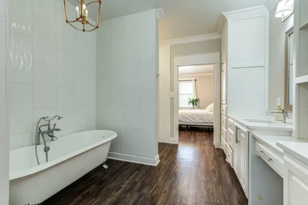 a en suite spacious bathroom with a granite countertop double vanity sink a mirror and shower