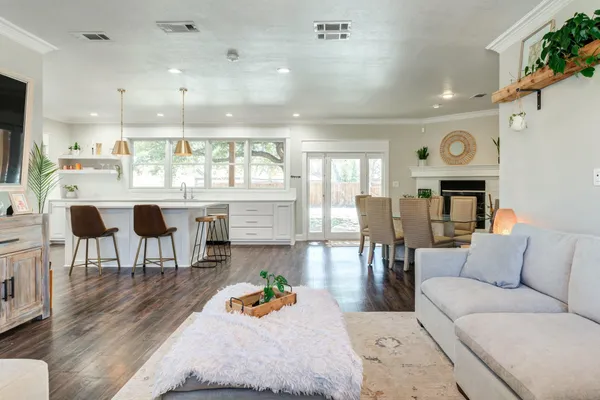 a living room with furniture a table and kitchen view
