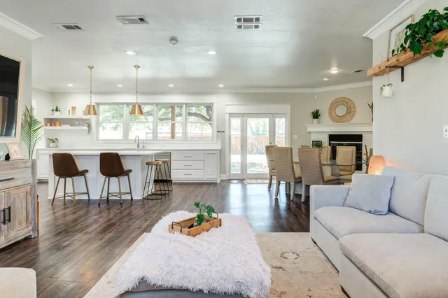 a living room with furniture a table and kitchen view