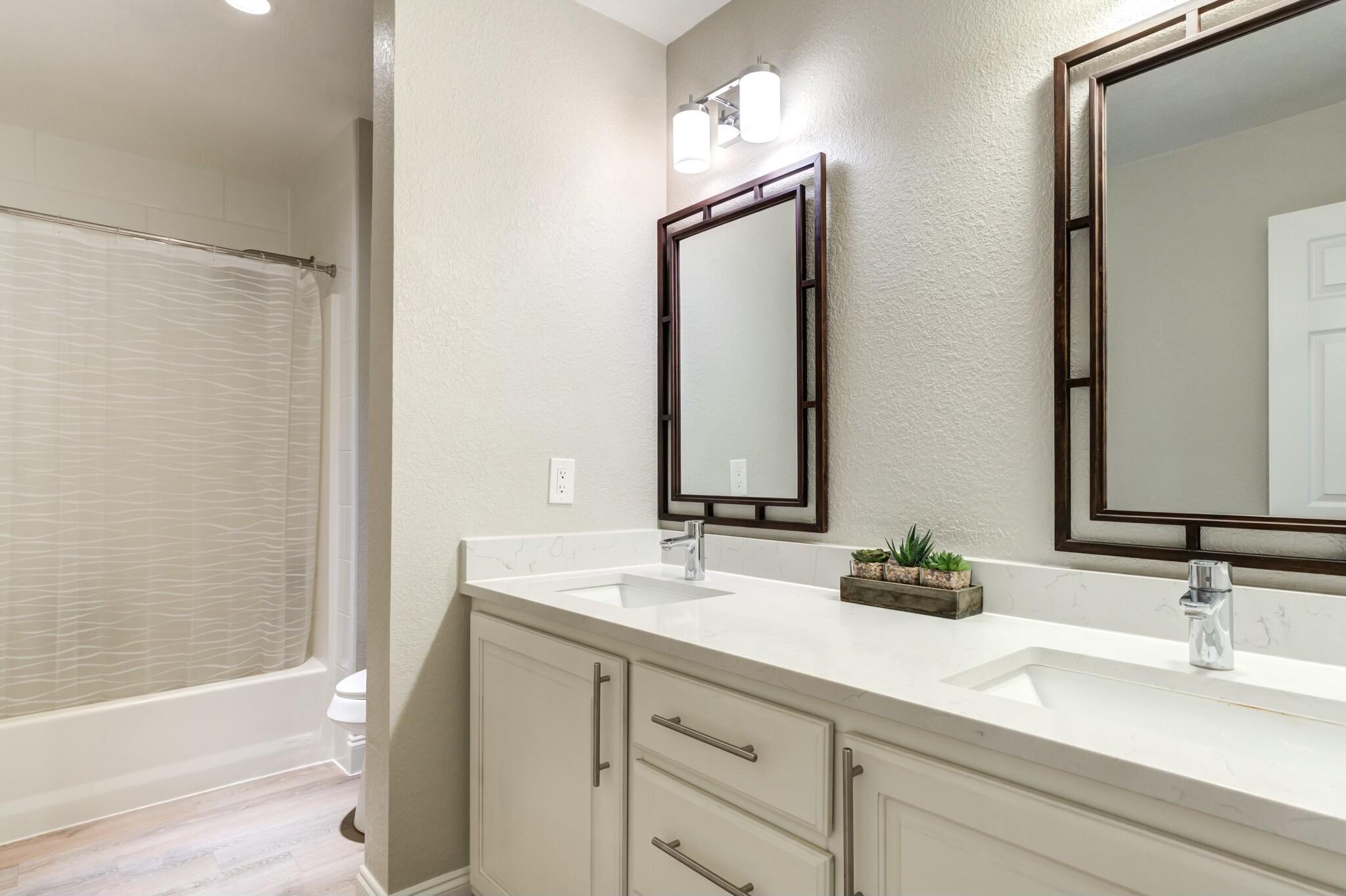 3219 22nd Street Lubbock, TX 79410 - Photo 37 of 51 a bathroom with a double vanity sink and a bathtub