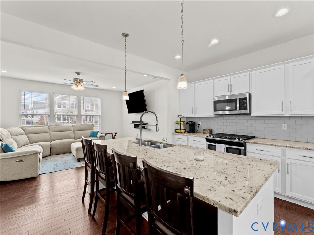 6135 Buntline Lane Richmond, VA 23234 - Photo 11 of 34 a kitchen with granite countertop a table chairs stainless steel appliances and cabinets