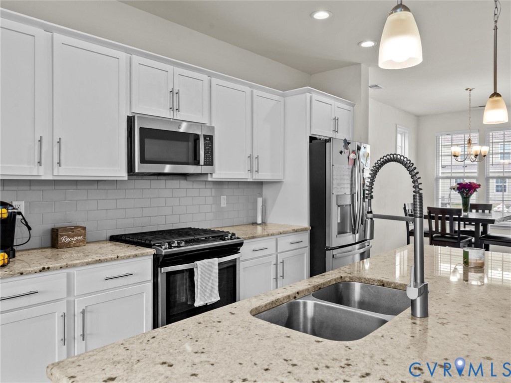 6135 Buntline Lane Richmond, VA 23234 - Photo 14 of 34 a kitchen with granite countertop a sink a counter space appliances and cabinets