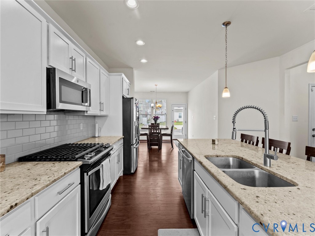 6135 Buntline Lane Richmond, VA 23234 - Photo 9 of 34 a kitchen with stainless steel appliances granite countertop a sink a stove top oven a counter space and cabinets