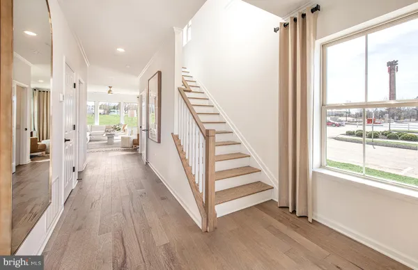 a view of a hallway with wooden floor and staircase