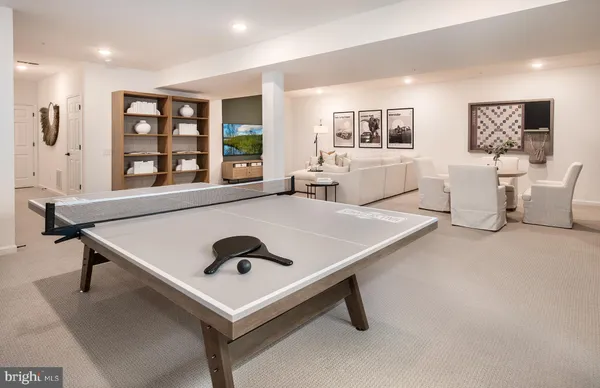 a living room with pool table and windows