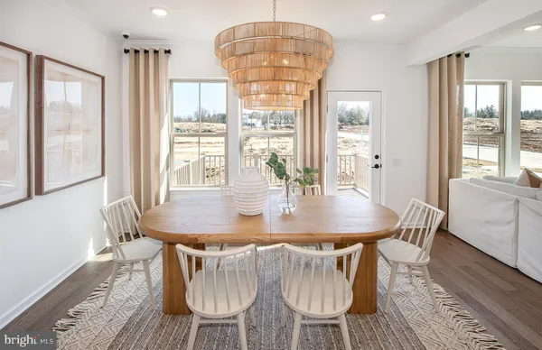 a dining room with furniture a chandelier and wooden floor