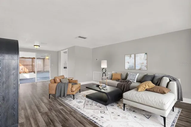 a living room with furniture and wooden floor