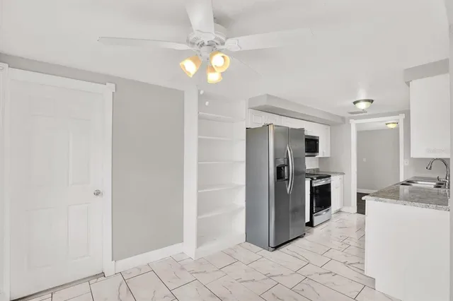 a kitchen with granite countertop a refrigerator and a sink