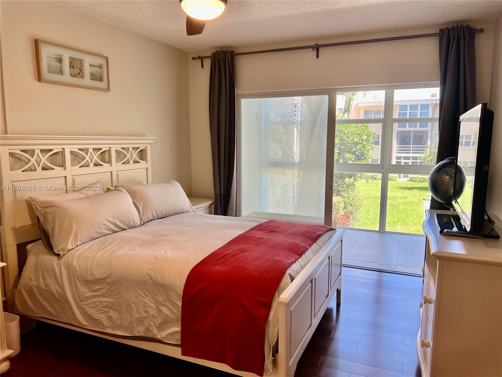 1481 South Ocean Boulevard, Unit 211E Lauderdale-by-the-Sea, FL 33062 - Photo 11 of 28 a bed sitting in a bedroom next to a window