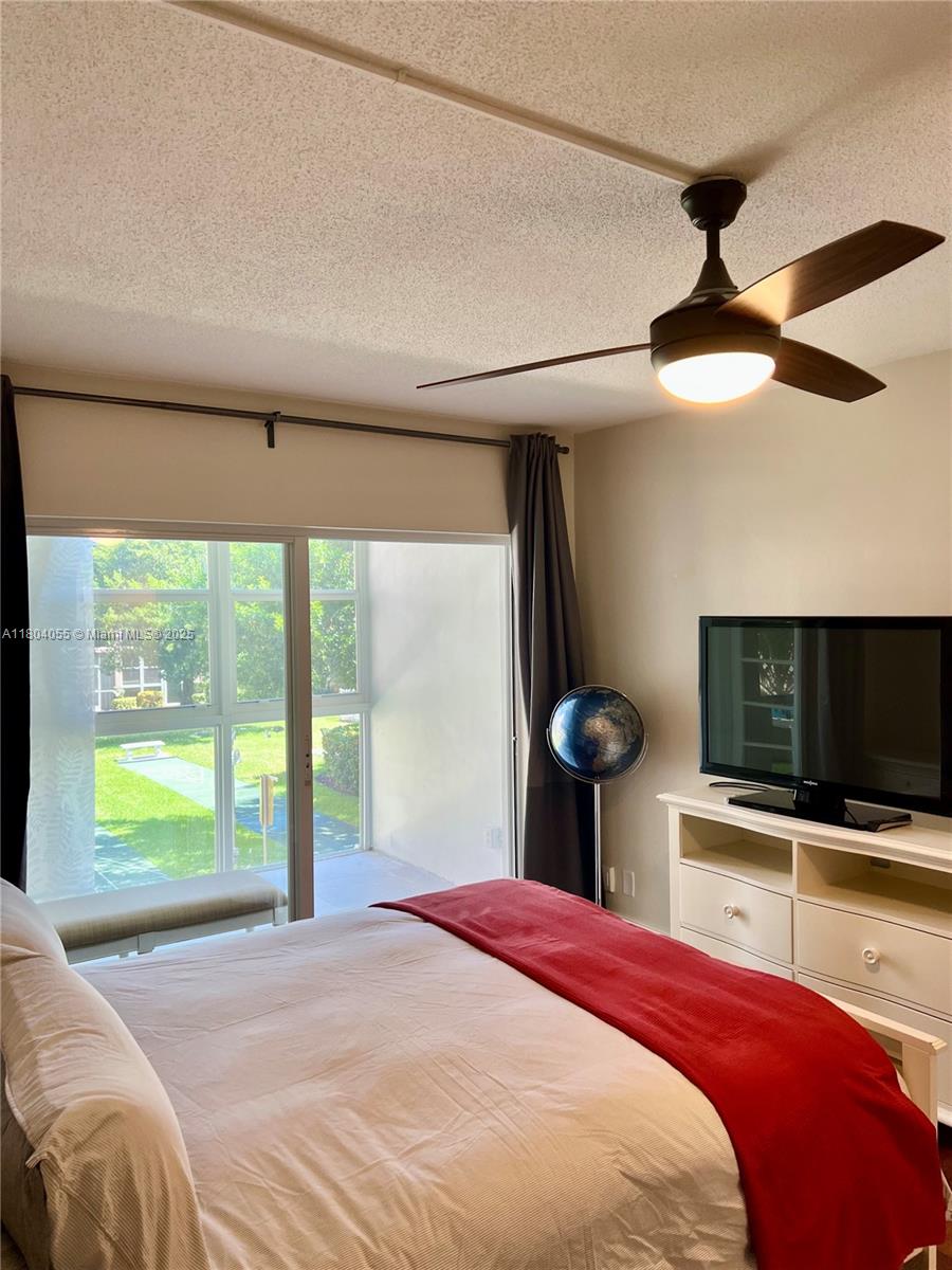 1481 South Ocean Boulevard, Unit 211E Lauderdale-by-the-Sea, FL 33062 - Photo 12 of 28 a bedroom with a bed and a flat screen tv