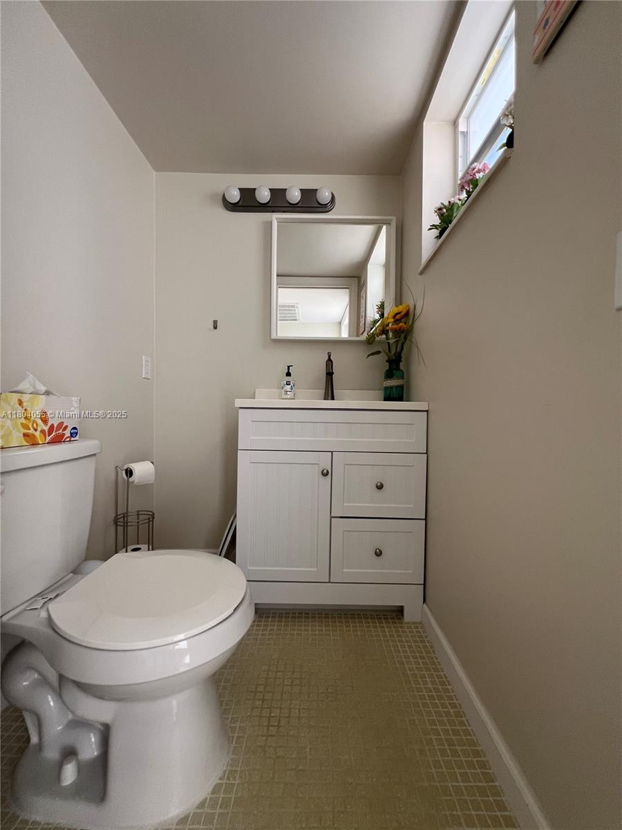 1481 South Ocean Boulevard, Unit 211E Lauderdale-by-the-Sea, FL 33062 - Photo 19 of 28 a bathroom with a toilet sink and mirror