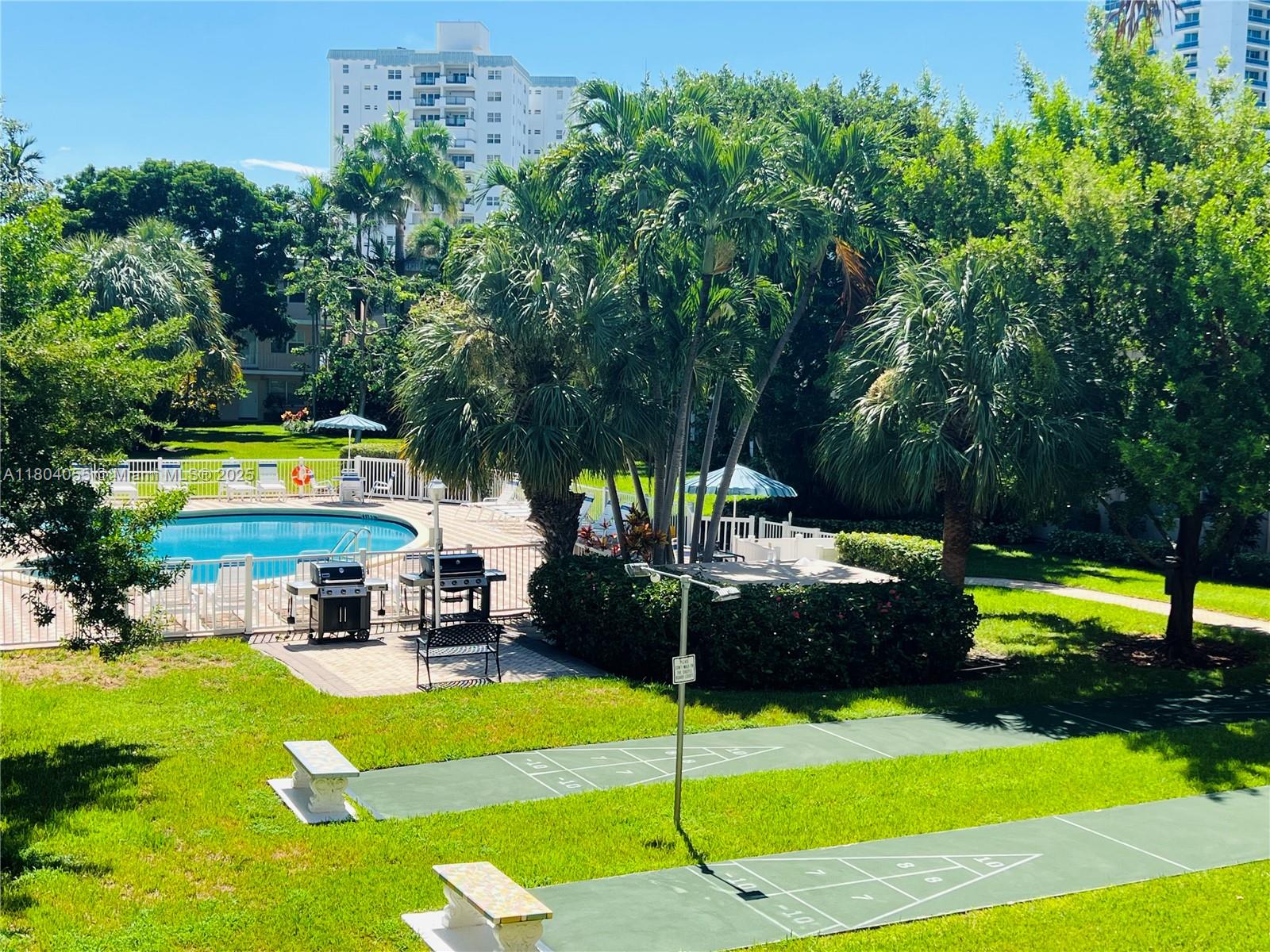 1481 South Ocean Boulevard, Unit 211E Lauderdale-by-the-Sea, FL 33062 - Photo 25 of 28 a view of a swimming pool with a garden
