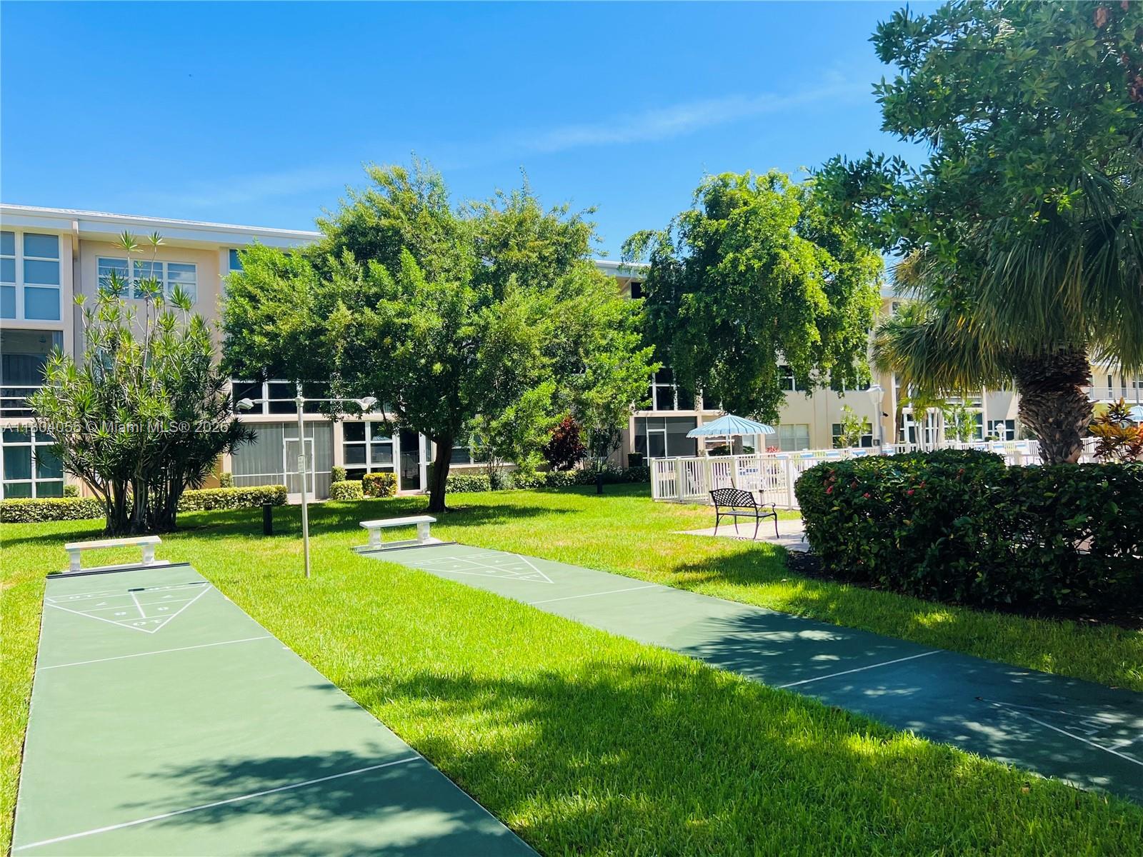 1481 South Ocean Boulevard, Unit 211E Lauderdale-by-the-Sea, FL 33062 - Photo 27 of 28 a front view of a house with a yard table and chairs