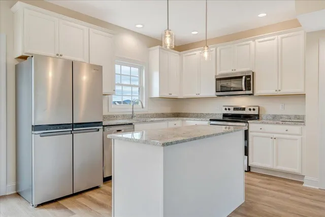 a kitchen with stainless steel appliances a refrigerator sink and microwave