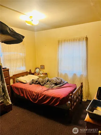 a bedroom with a bed and teddy bear on bed