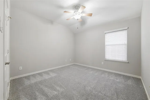 a view of a room with a ceiling fan and a window