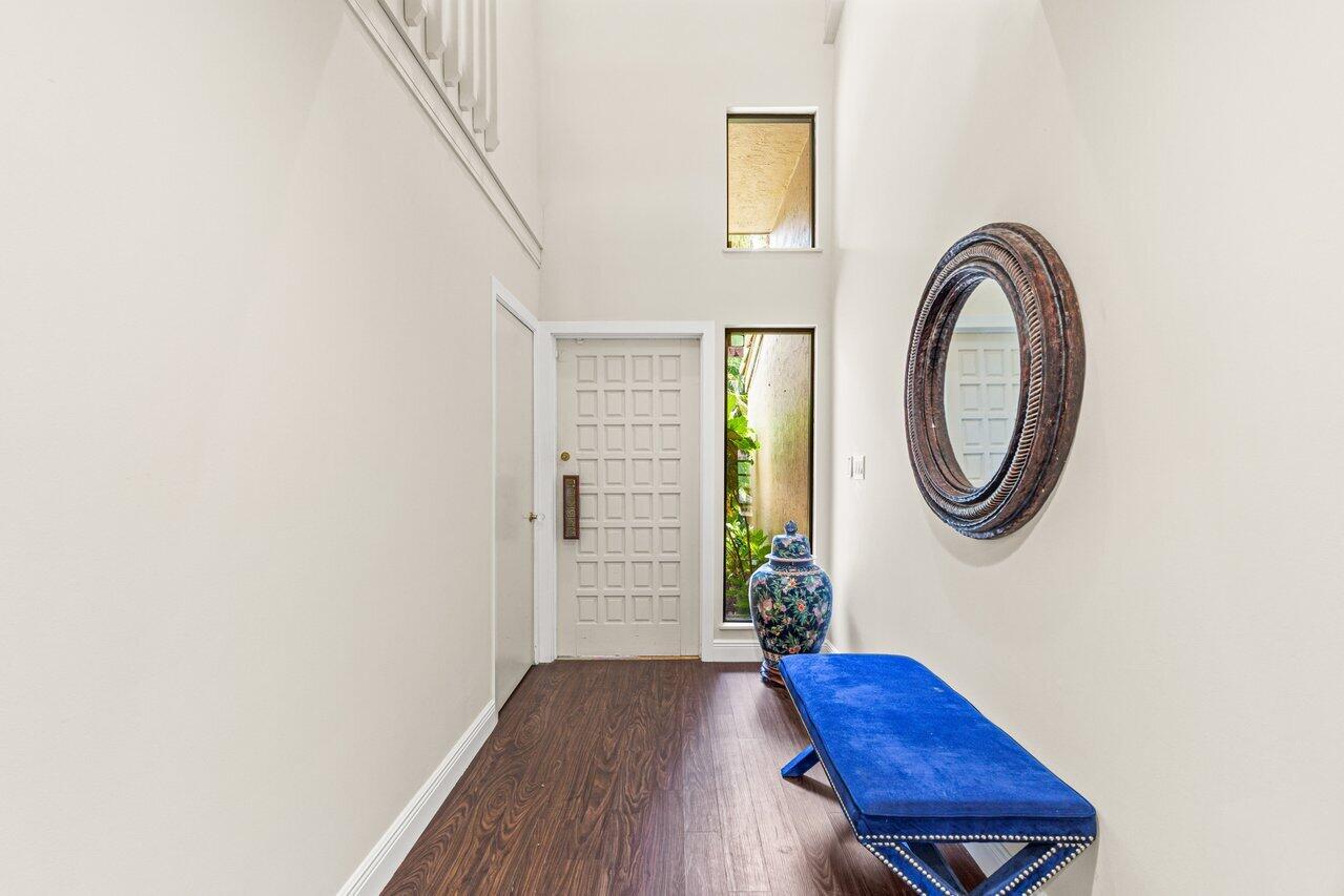 7517 Cedarwood Circle Boca Raton, FL 33434 - Photo 3 of 63 a view of a hallway with entryway wooden floor and a dining table