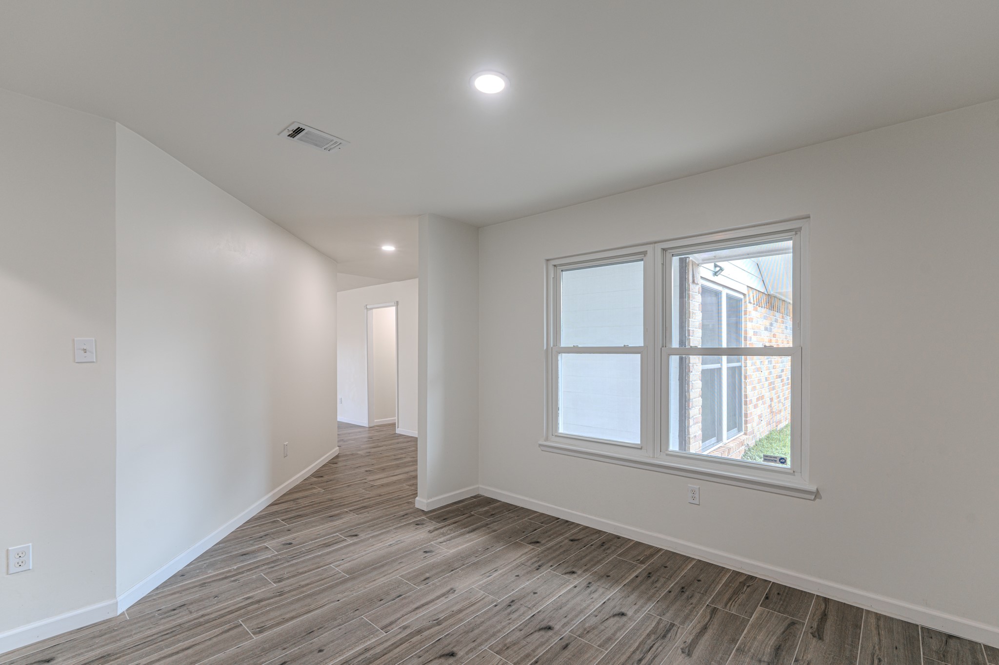 5819 Sunnygate Drive Spring, TX 77373 - Photo 7 of 26 a view of an empty room with wooden floor and a window
