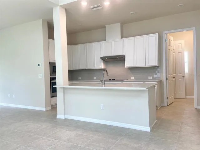 a kitchen with granite countertop white cabinets and a stove