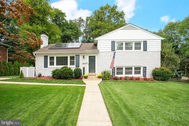 a front view of a house with a yard and trees