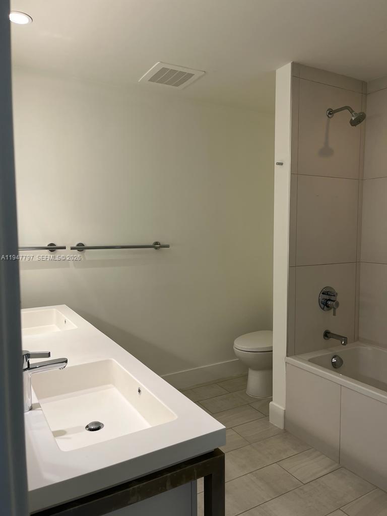 2000 Metropica Way, Unit 1602 Sunrise, FL 33323 - Photo 17 of 50 a bathroom with a sink a toilet and shower