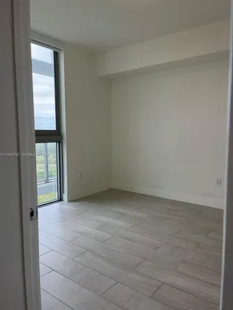 a view of an empty room with glass door and balcony
