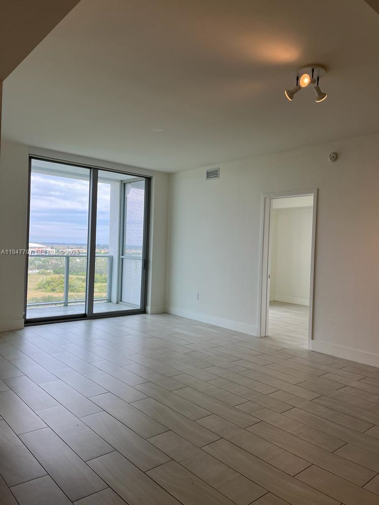 2000 Metropica Way, Unit 1602 Sunrise, FL 33323 - Photo 19 of 50 a view of an empty room with glass door and balcony