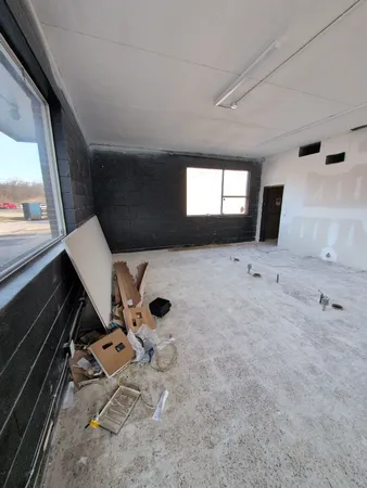 a living room with a couch and a stove next to a window