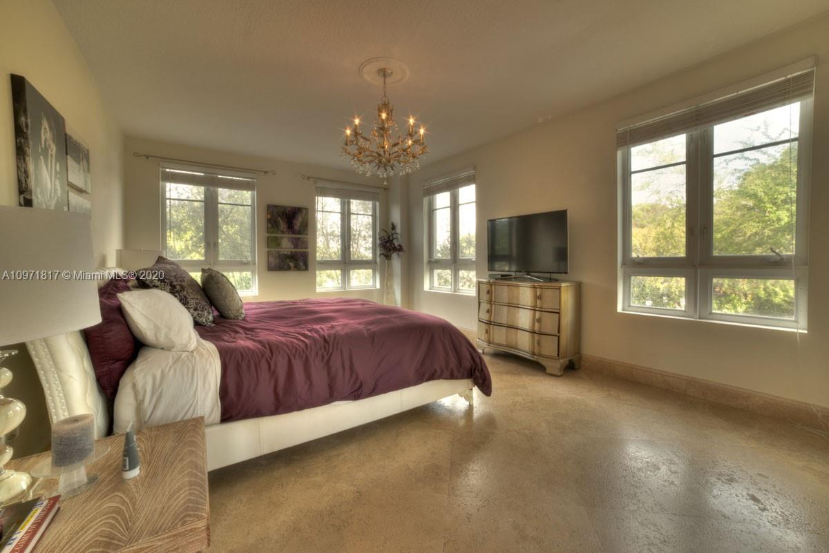 3540 Main Highway, Unit 301 Miami, FL 33133 - Photo 12 of 29 a spacious bedroom with a bed and glass windows