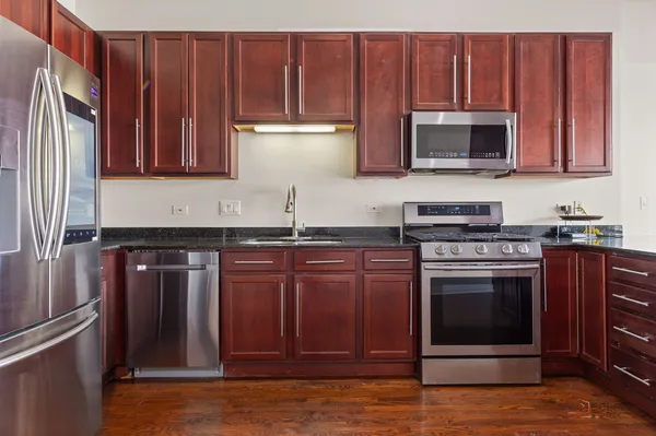 a kitchen with granite countertop wooden cabinets and stainless steel appliances
