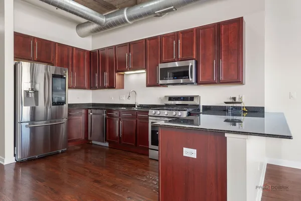 a kitchen with stainless steel appliances granite countertop a refrigerator stove top oven a sink and dishwasher