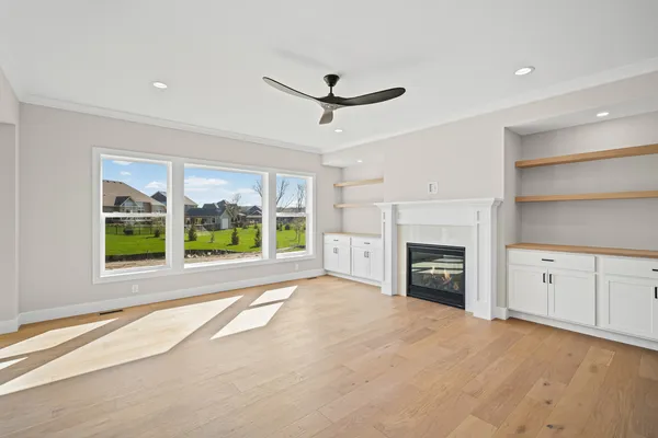 a view of an empty room with a fireplace and a window