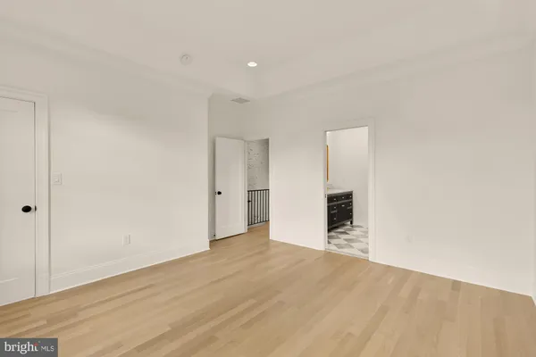 a view of an empty room with wooden floor and cabinet