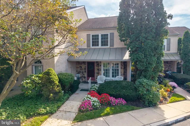 a front view of a house with a yard and potted plants
