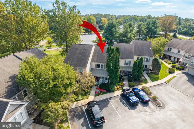 an aerial view of residential houses with outdoor space and trees