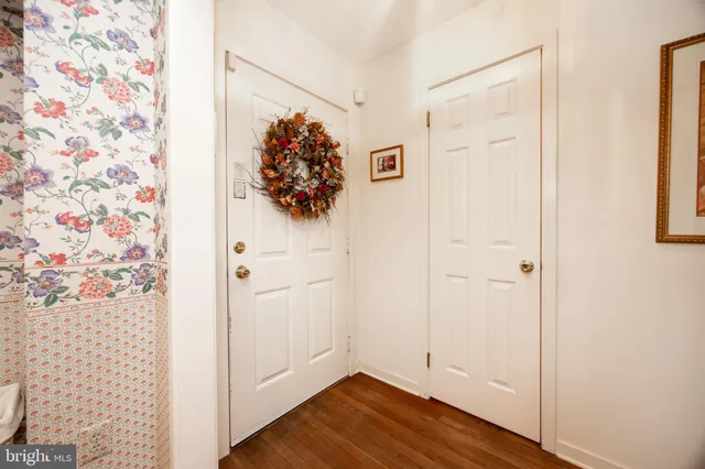 a view of a hallway with wooden floor and closet