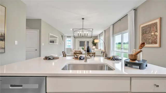 a view of living room with granite countertop furniture a ceiling fan a table and a chandelier